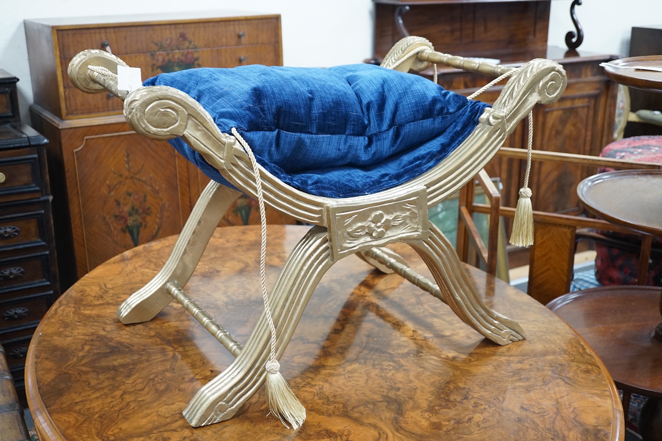 A Regency style carved and fluted giltwood x-frame stool, width 76cm, depth 47cm, height 52cm